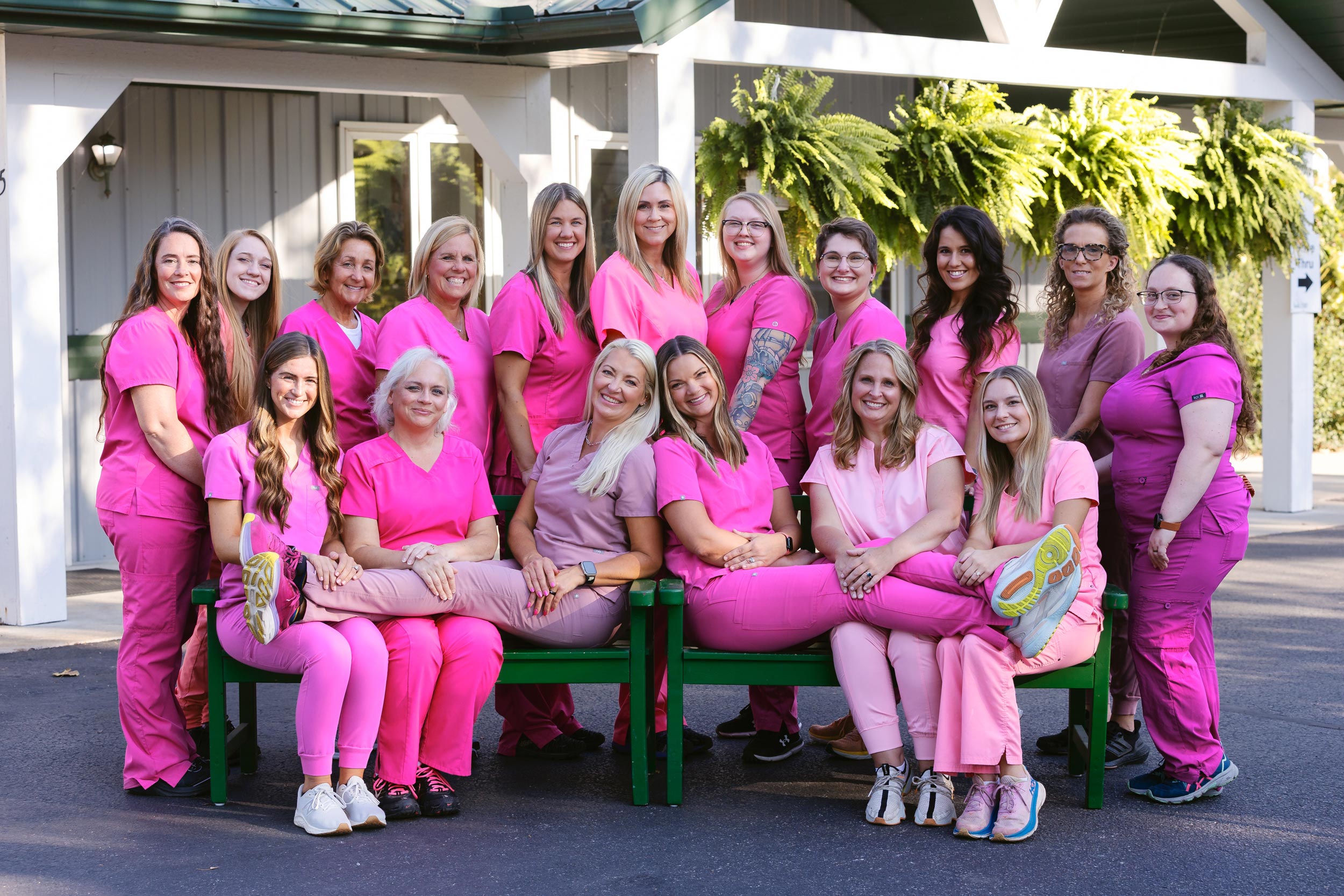 Photo of the entire staff of Middlebury Animal Clinic, outside of their clinic building during the fall season.